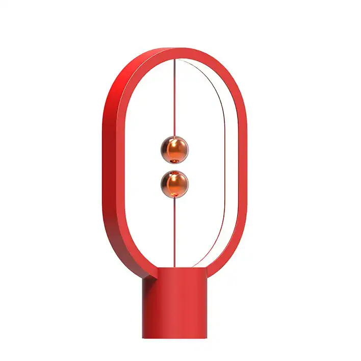 lampe-heng-balance-mini-rouge-1 Lampe Newton en verre rouge avec cadre ovale en métal, design moderne et scientifique, idéale pour décoration de bureau ou salon.