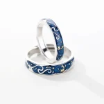 Anneaux de mariage en acier avec motif de vagues et étoiles dorées, symbolisant l'océan et la navigation, parfaits pour un couple passionné par la mer ou la science marine.