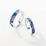 Anneaux en acier avec motif océanique en émail bleu, parfaits pour symboliser l'amour et la passion liés à la mer.