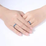 Deux mains portant des bagues en acier inoxydable avec motifs scientifiques, symbolisant l'amour et la passion pour la science.