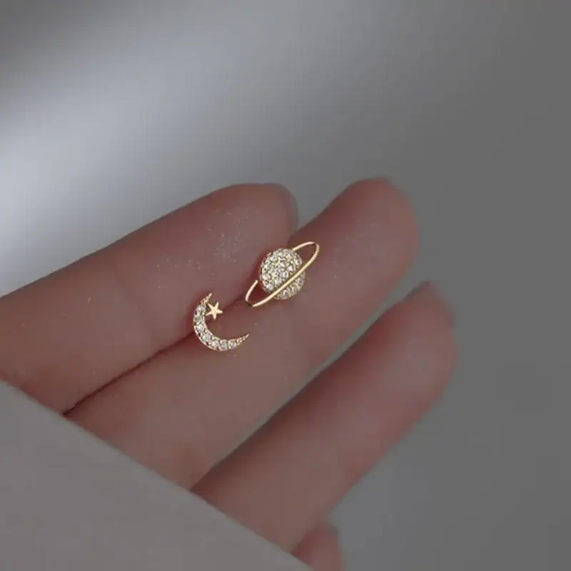 boucle-doreille-espace-or-1 Bijou d'oreille en forme de lune et d'étoile ornée de diamants, symbolisant la celestialité et l'élégance.