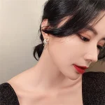 Une femme portant une boucle d'oreille en forme de croissant avec une étoile, mettant en valeur un style sophistiqué et moderne.