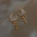 Boucles d'oreilles en forme de croissant de lune avec étoiles pendantes, bijoux fantaisie inspirés de l'astronomie, parfaits pour une touche céleste.