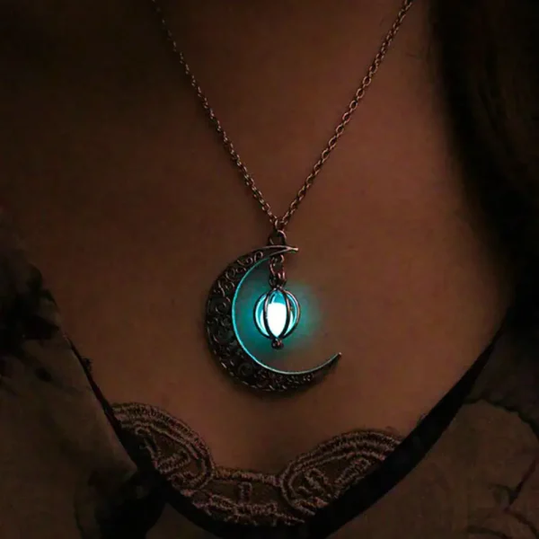 Pendentif lune et étoile lumineux suspendu à une chaîne, illuminant doucement dans l'obscurité, idéal pour la décoration ou comme bijou original.