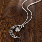 Pendentif lune en métal argenté avec bracelet à chaîne, bijou de style cosmique et mystique.