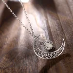 Collier avec pendentif lune en métal finement gravé et pierre centrale, idéal pour une touche élégante et mystique.