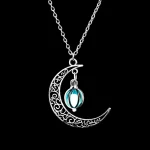 Pendentif en forme de lune avec un motif orné et un pendentif moléculaire en verre bleu, suspendu à une chaîne en argent. Un bijou scientifique élégant et original.