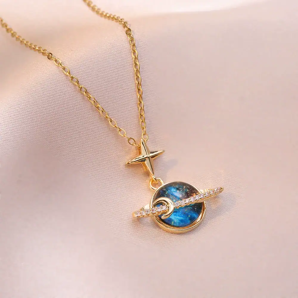 collier-espace-cristal-1 Collier avec pendentif étoile et planète, en or et argent, inspiré de l'astronomie, parfait pour les amateurs de science et d'astrophysique.