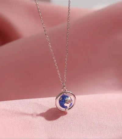 Collier avec pendentif globe terrestre miniature en argent, symbole de voyage et de découverte.