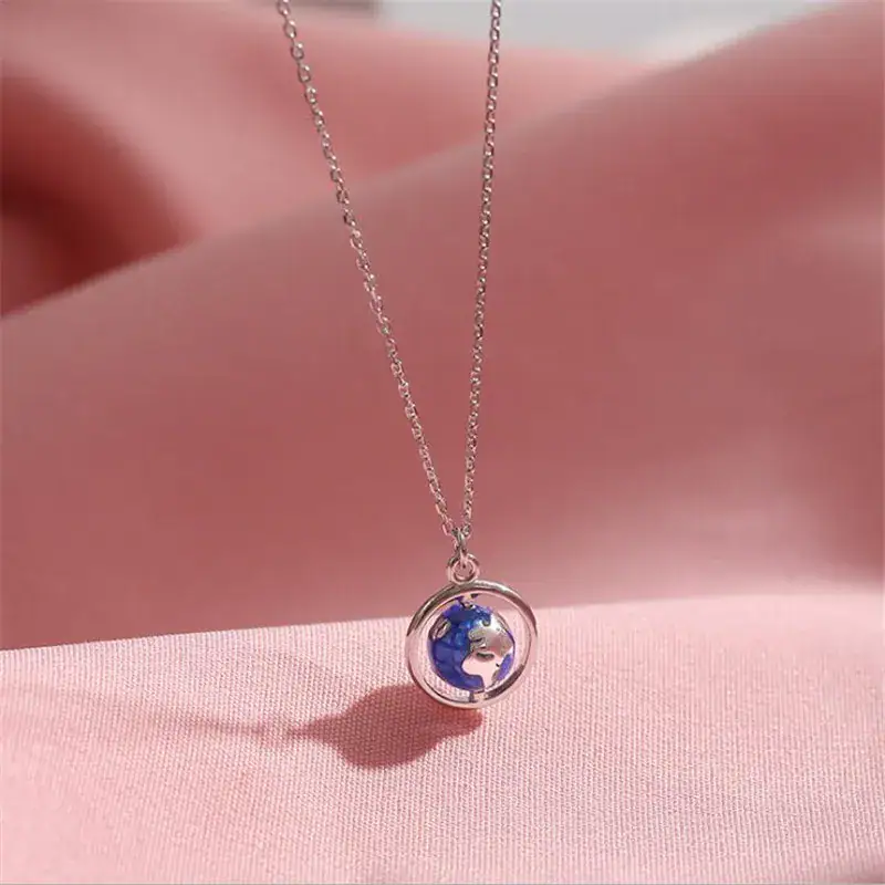 collier-globe-terrestre-1 Collier avec pendentif globe terrestre miniature en argent, symbole de voyage et de découverte.