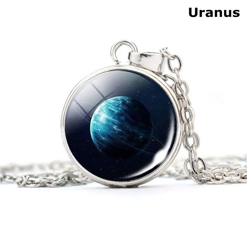 collier-planete-uranus-1 Pendentif en métal avec image de la planète Uranus, représentant un corps céleste bleu et glacé, suspendu à une chaîne en métal argenté.