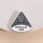 Une broche ou badge représentant la mission Apollo 11 de la NASA, avec la date 1969, symbole emblématique de l'exploration spatiale.