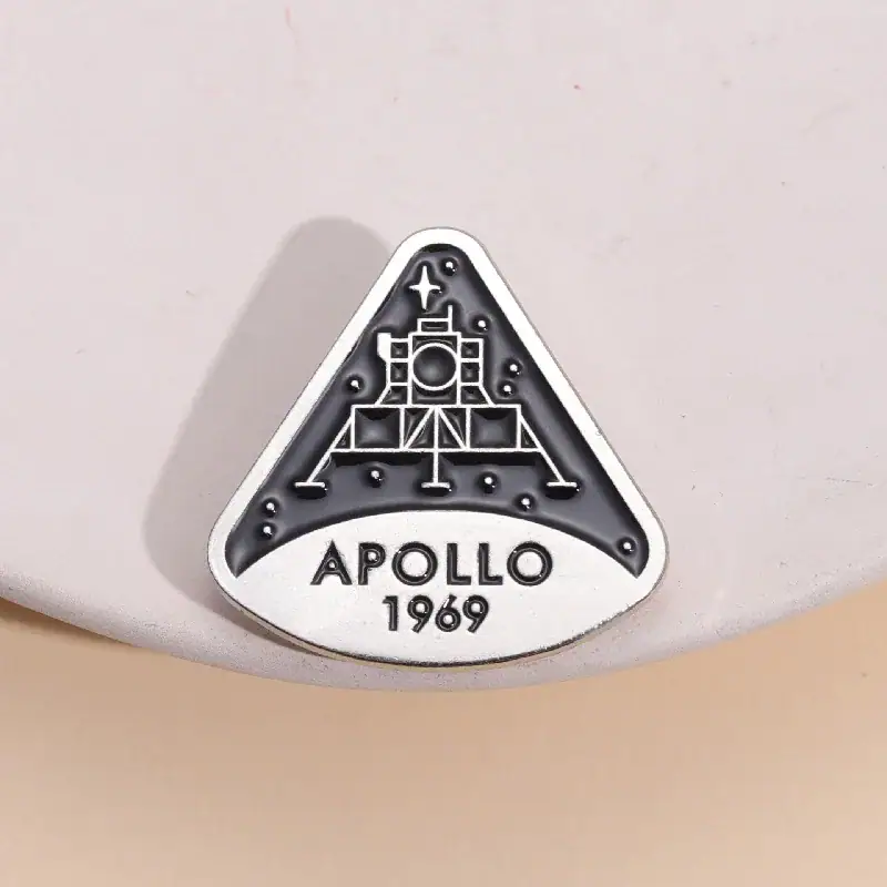 Une broche ou badge représentant la mission Apollo 11 de la NASA, avec la date 1969, symbole emblématique de l'exploration spatiale.