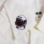 Patch d'astronaute avec visage soviétique sur un vêtement blanc, symbole de l'exploration spatiale et de l'histoire soviétique.