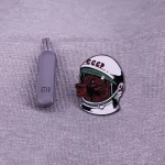 Puce USB grise à côté d’un badge représentant un astronaute soviétique avec casque et logo CCCP.