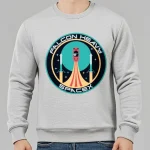 Sweatshirt gris avec logo Falcon Heavy SpaceX, illustration d'une fusée en lancement dans un style graphique moderne, idéal pour les amateurs d'espace et de technologie.