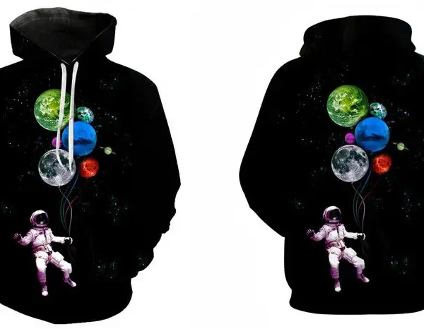 Vêtement à capuche noir avec un motif d'espace, comprenant un astronaute flottant dans l'espace avec des planètes colorées, idéal pour les amateurs de science et d'astronomie.