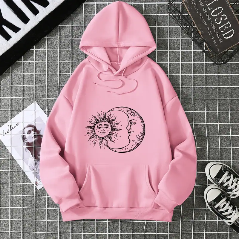 sweat-soleil-lune-1 Sweat à capuche rose avec motif solaire et lune en noir, style décontracté, parfait pour la mode urbaine et la décoration intérieure.