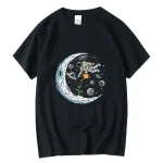 T-shirt noir avec illustration d'un astronaute flottant dans l'espace, entouré de planètes, étoiles et une lune brillante, parfait pour les amateurs de science et d'astronomie.
