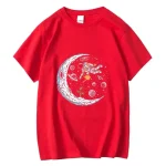 T-shirt rouge avec illustration d'une astronaute flottant près d'une lune stylisée, entourée de planètes et d'étoiles, parfait pour les amateurs d'espace et de science.