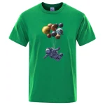 T-shirt vert avec motif d'astronaute et planètes suspendues, idéal pour les amateurs d'espace et de science.