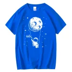 T-shirt bleu avec design d'astronaute suspendu à la lune, ambiance spatiale ludique et originale.