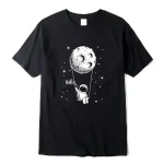 T-shirt noir avec illustration d'un astronaute suspendu à la lune, accompagnée du mot "Hello" dans un style graphique simple et moderne.