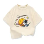 Vêtement enfant avec motif d'astronaute et planète, illustrant un voyage spatial avec une fusée, une planète et un astronaute en combinaison.