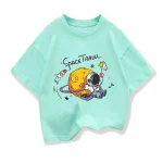 T-shirt pour enfant avec design de planète, astronaute et fusée dans un style ludique et coloré. Parfait pour les amateurs d'espace et de science.