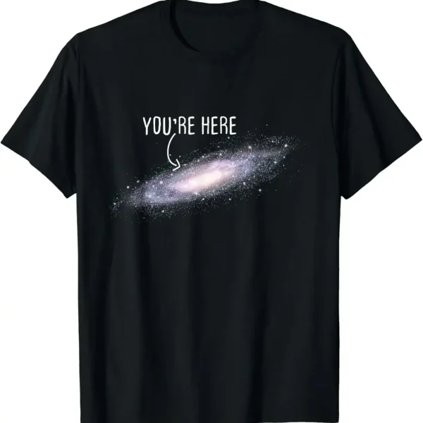 T-shirt galaxie avec texte "You're Here" en blanc sur fond noir, représentant une galaxie spirale avec un message humoristique et cosmique.