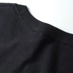 Vêtement noir uni, près du col, en tissu doux et confortable.
