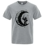 T-shirt gris avec illustration d'un astronaute sur la lune, style artistique et moderne, parfait pour les amateurs de science et d'astronomie.