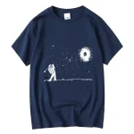 T-shirt bleu marine avec illustration d'un astronaute jouant au golf dans l'espace, avec une galaxie en spirale en arrière-plan.