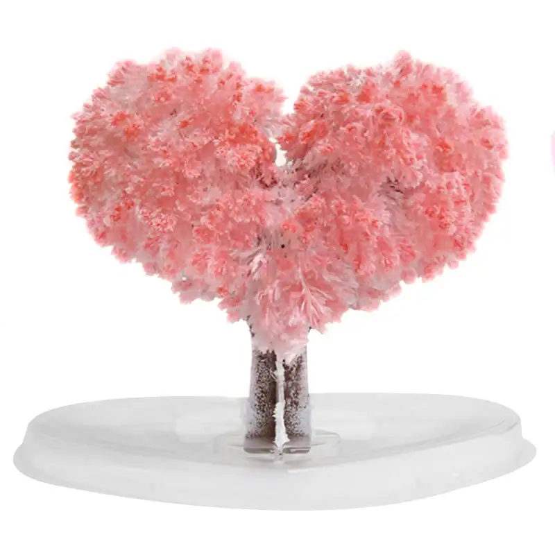 arbre-a-cristaux-1 Sculpture artistique représentant un cœur formé par un arbre de coton rose, posé sur une base blanche, évoquant la douceur et la tendresse.