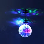 Lampe suspendue en forme de boule projetant des lumières colorées sur le plafond, créant une ambiance lumineuse et artistique.