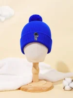 Bonnet en laine bleu avec un petit logo d'astronaute brodé, orné d’un pompon en laine. Parfait pour les amateurs de science et de style décontracté.