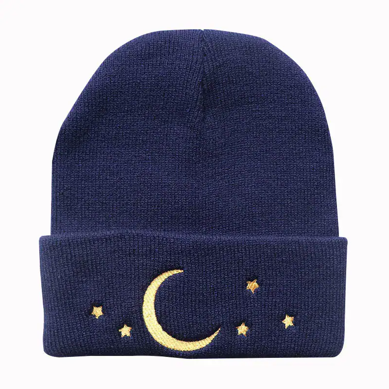 bonnet-lune-1 Bonnet en laine bleu marine orné d’un motif lune et étoiles dorées, parfait pour l’hiver ou comme accessoire de mode original.