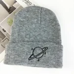 Bonnet en laine gris avec logo d'une planète entourée d'anneaux, parfait pour l'hiver ou comme accessoire de mode scientifique.