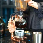 Pipette à distillation en verre utilisée pour des expériences scientifiques, avec un système de chauffage et de refroidissement.