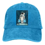 Casquette en denim bleu avec patch d'astronaute illustré, parfait pour les amateurs de science et d'exploration spatiale.