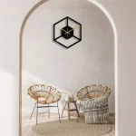 Horloge murale en forme de cube avec design minimaliste, noir et doré, ajoutant une touche contemporaine à la décoration intérieure.