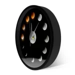 Horloge murale représentant les différentes phases de la lune, avec un design minimaliste noir et des détails en nuances de gris et orange, idéale pour la décoration scientifique.