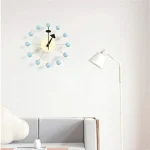 Horloge murale moderne avec éléments en forme de sphères bleues.