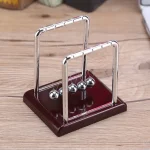 Péde à Newton en métal et bois, outil scientifique pour démonstration de lois de la physique, parfait pour l'enseignement et la décoration de style scientifique.