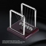 Pêndule de Newton en métal brillant avec six sphères suspendues, sur base en bois foncé, illustrant la physique et la décoration scientifique.