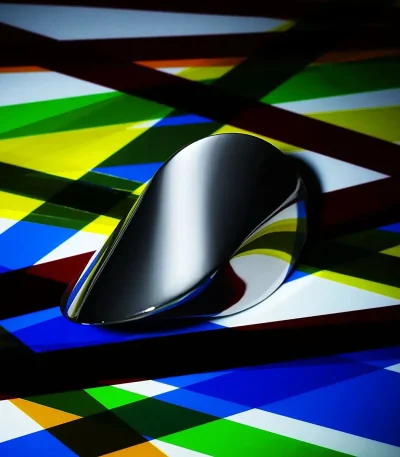 Pointeur de souris noir brillant placé sur un fond coloré abstrait avec des lignes diagonales multicolores.