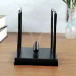 Péndule de Newton classique avec boules en métal suspendues, idéale pour la décoration scientifique ou comme objet éducatif dans un bureau ou une salle de classe.