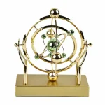 Horloge scientifique décorative en métal doré avec sphères et bras articulés, idéale pour la décoration de bureau ou d'étagère.