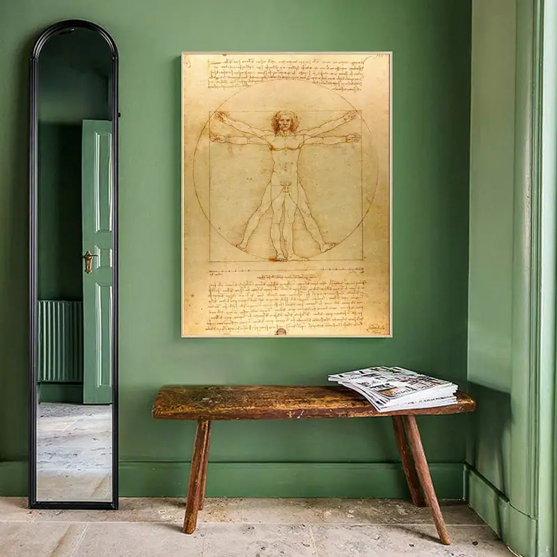 poster-leonardo-da-vinci-lhomme-de-vitruve-1 Reproduction du célèbre dessin de Léonard de Vinci, représentant l'homme de Vitruve avec ses proportions idéales, affiché sur un mur vert dans une pièce élégante.