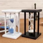 Sablier en bois noir et blanc avec verre transparent, décoration de style scientifique, idéal pour une boutique ou un espace de décoration thématique scientifique.